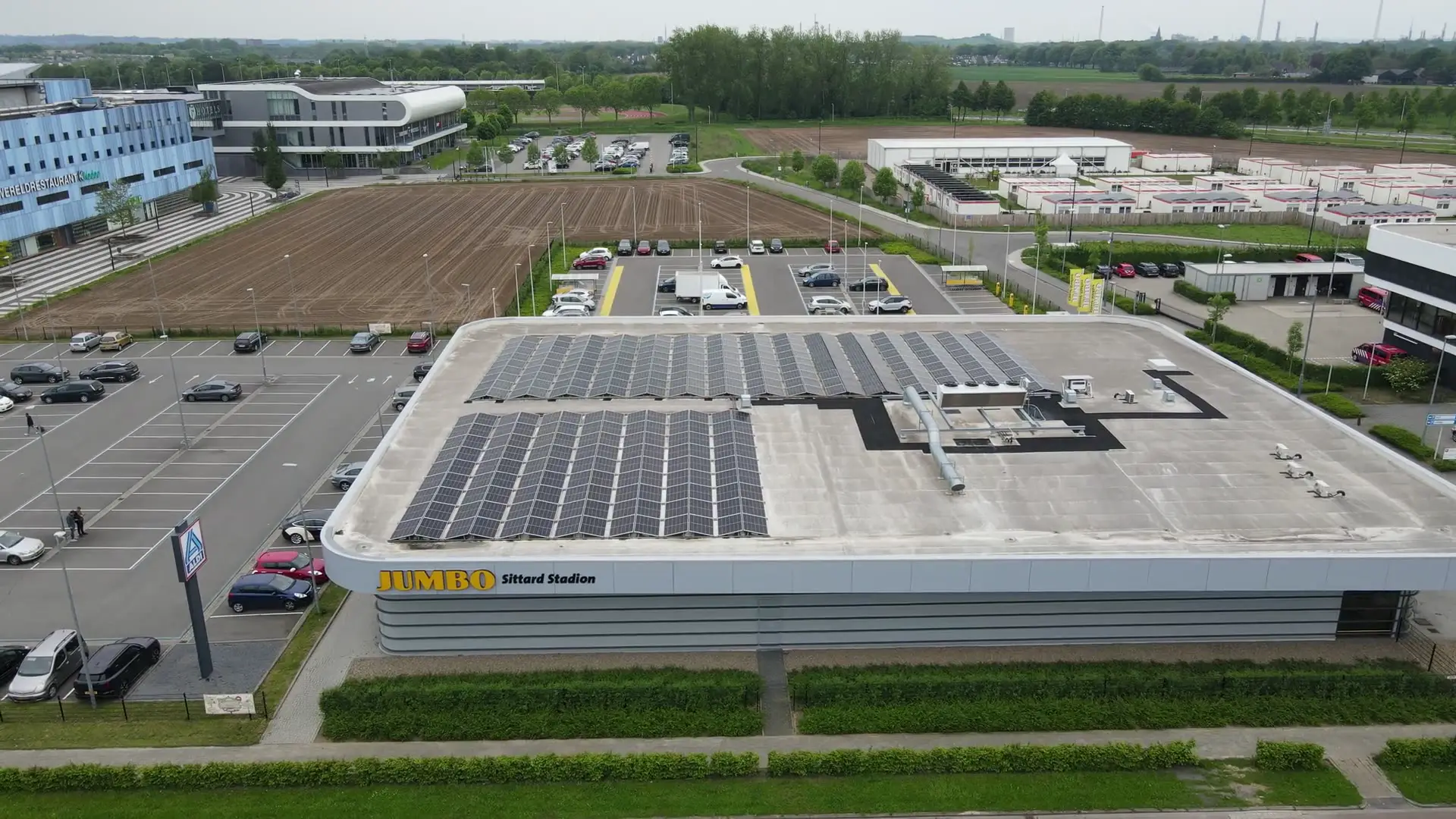 Luchtfoto van een supermarkt in Sittard met zonnepanelen op het platte dak